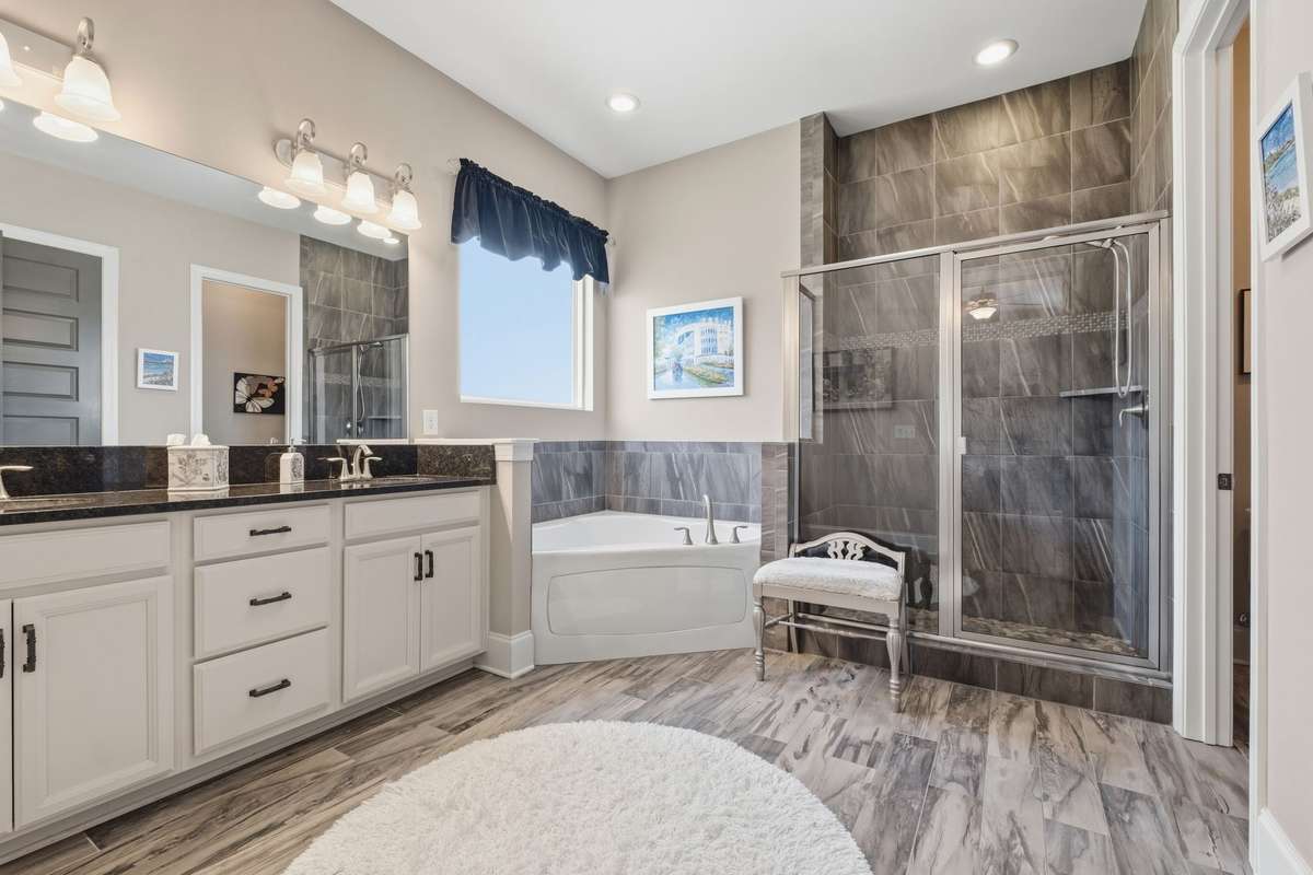 Spacious Owners suite bath with separate shower and tub, his and hers vanity area, separate commode closet and linen closet.