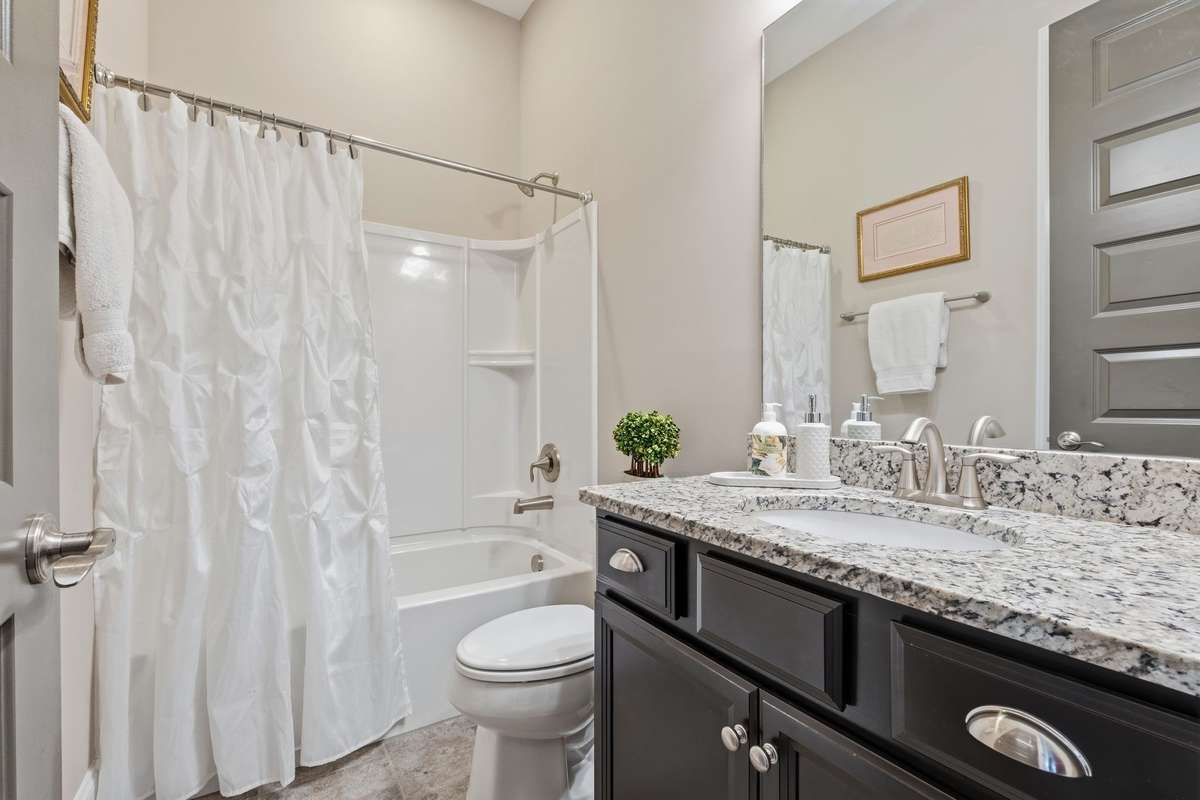 Upstairs Full Bath with tile floors and granite counter top.