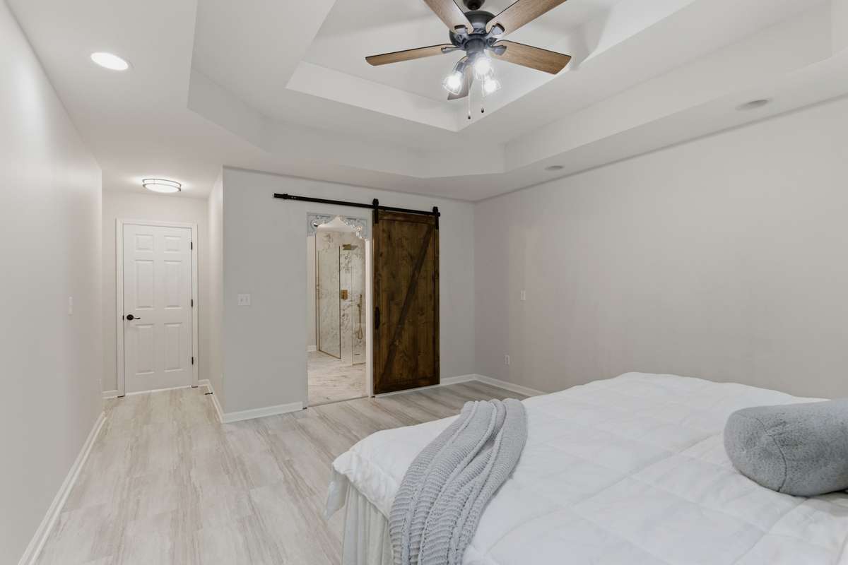 Private and Peaceful primary suite featuring modern finishes, soft natural tones and great barn door
