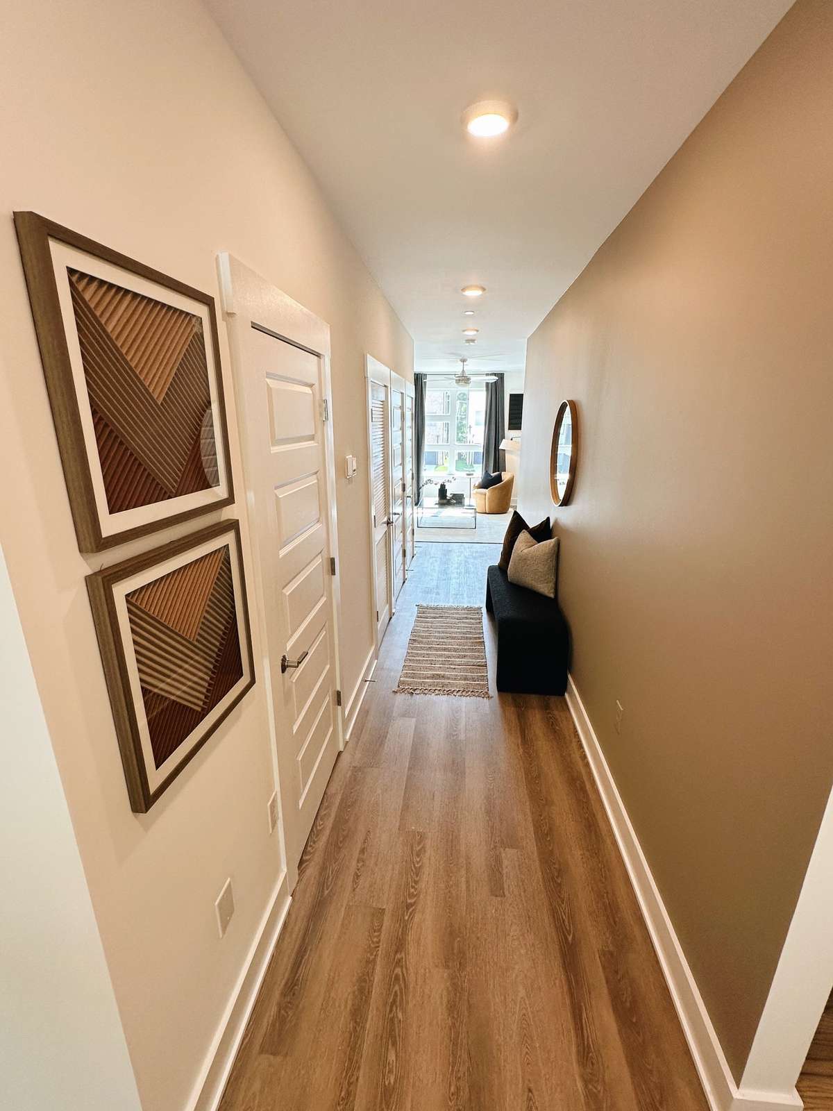 Hallway to living room area on the second floor (Photo is taken from the kitchen area) - Hallway half bath is on the left.