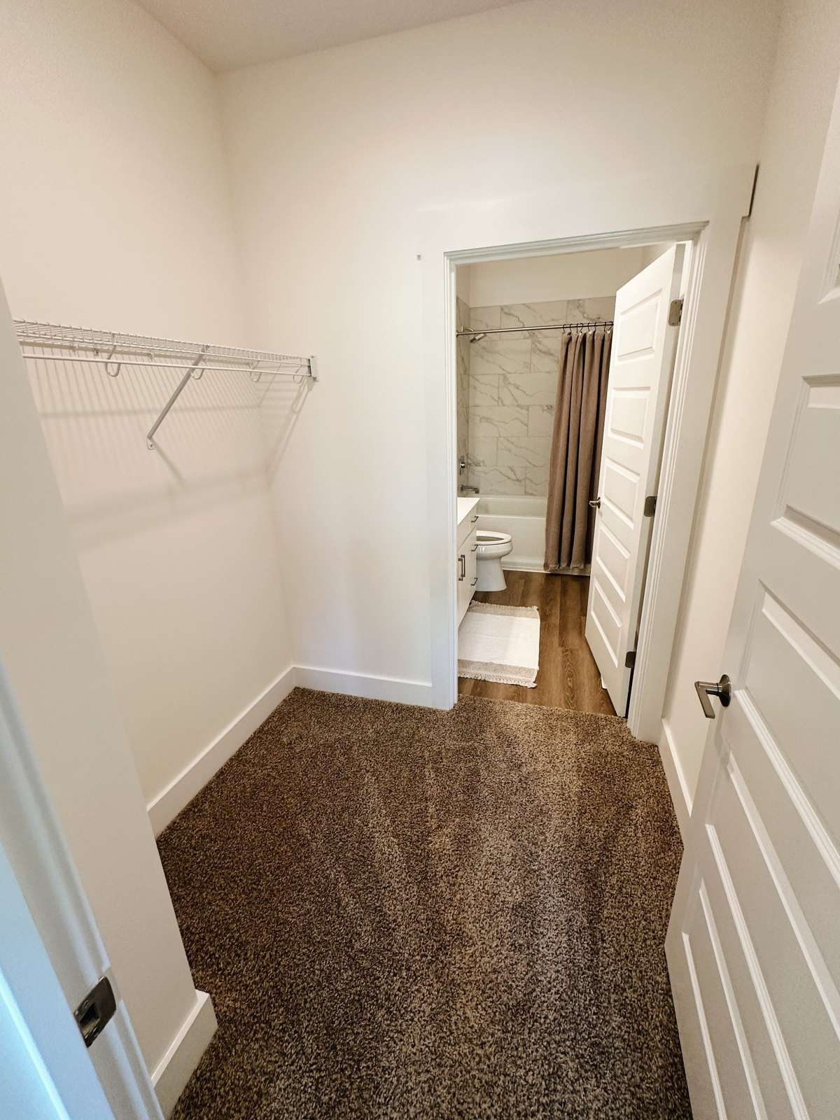 Primary suite closet into private bathroom.