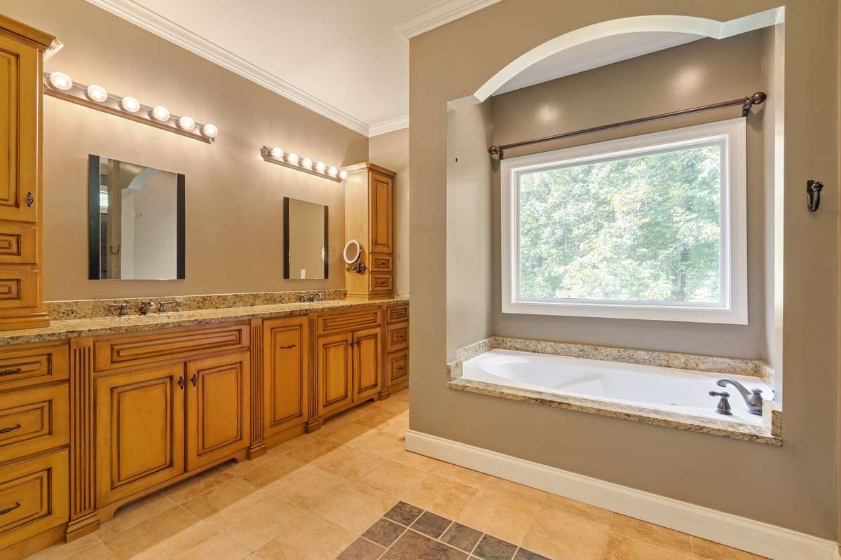 Primary bathroom with double vanities and separate tub