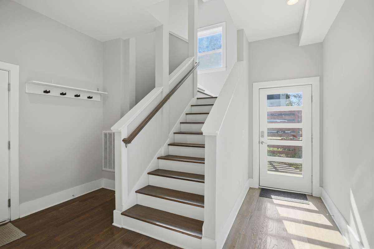 Front door entry way. Hardwood floors throughout add warmth and timeless style to every space. Garage access to the left of the stairs.