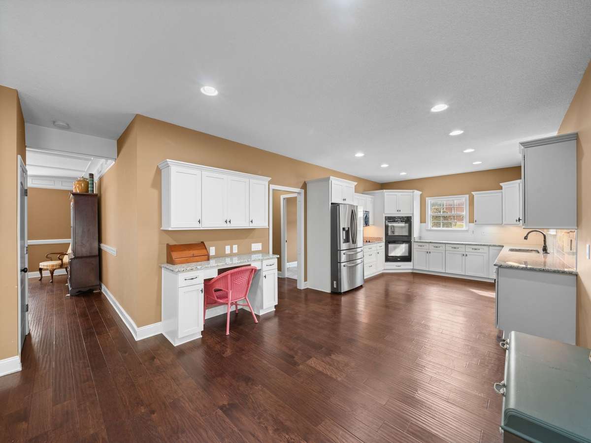 Spacious kitchen with built in desk and seamless flow into dining and living areas.