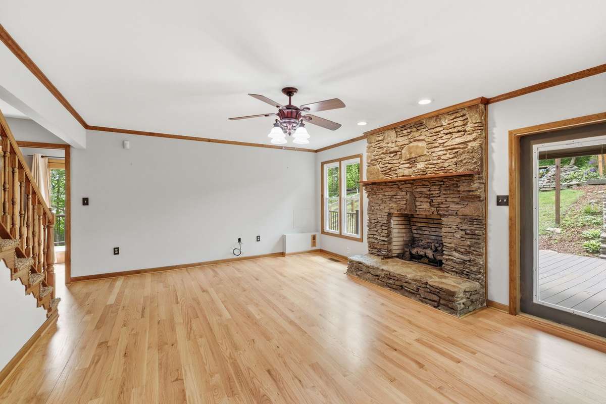 den featuring a stacked stone fireplace with new, remote gas logs