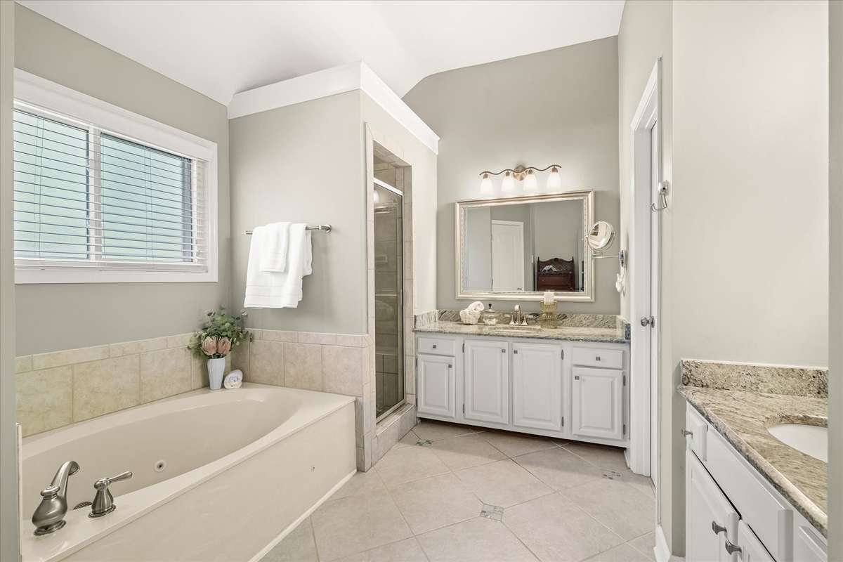 Primary bathroom is clean and neutral, featuring dual vanities and separate closets—because sharing is overrated.
