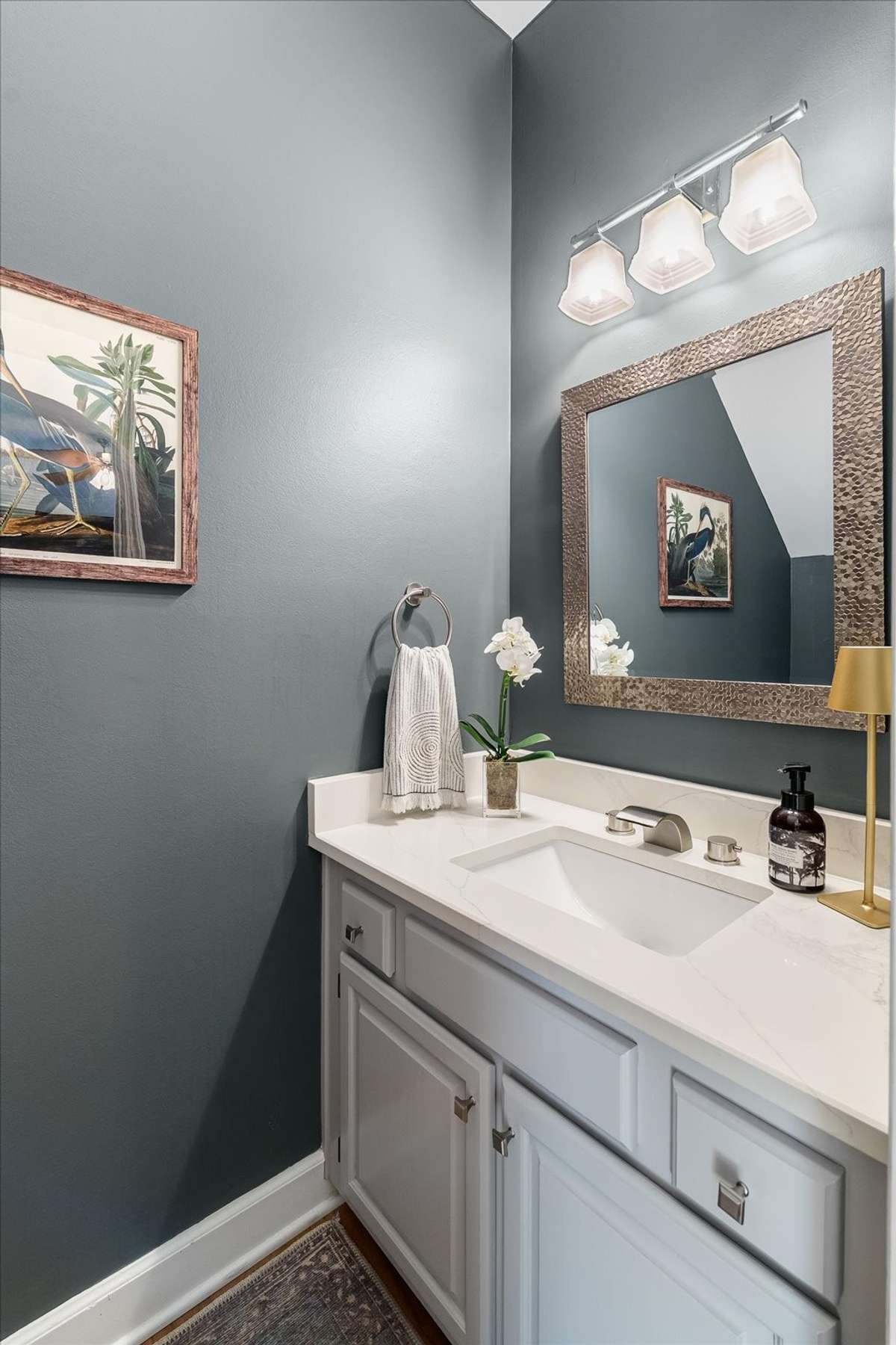 Updated powder room with quartz countertops—because even the quickest stop should feel a little elevated.