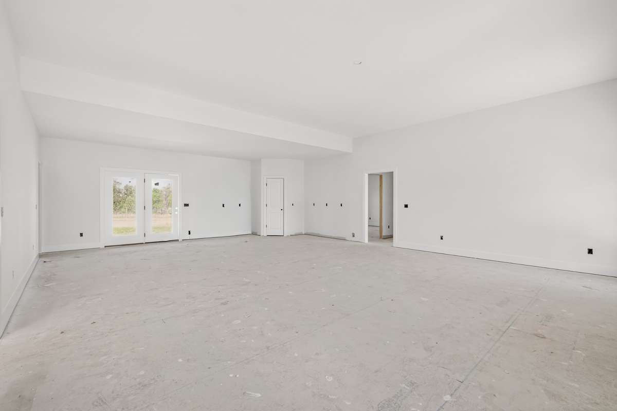 This open floor plan with high ceilings brings the living room, kitchen, and dining space together