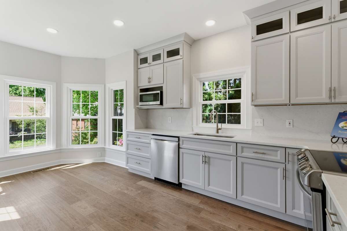 Completely reimagined, "to the studs" kitchen showcasing ceiling height custom cabinetry, stunning Taj Mahal quartzite countertops with full height backsplash.