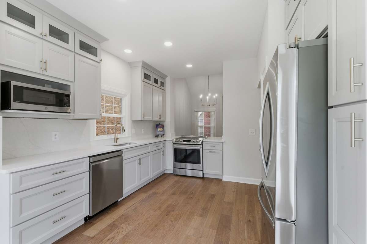 Champagne bronze fixtures, deep basin sink and stainless appliances.