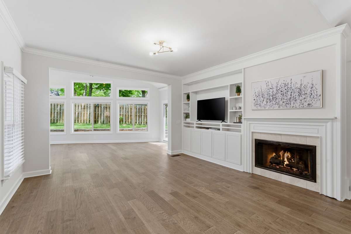 Inviting great room anchored by a gas fireplace and custom built-ins, with all new wide plank hardwood flooring.  Designed for effortless entertaining, the space flows seamlessly into a secondary living area, creating and open and versatile layout.