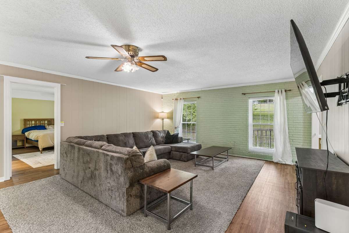This expansive living room features stunning brick accent walls and a cozy fireplace—blending character and comfort for the perfect place to relax or entertain.