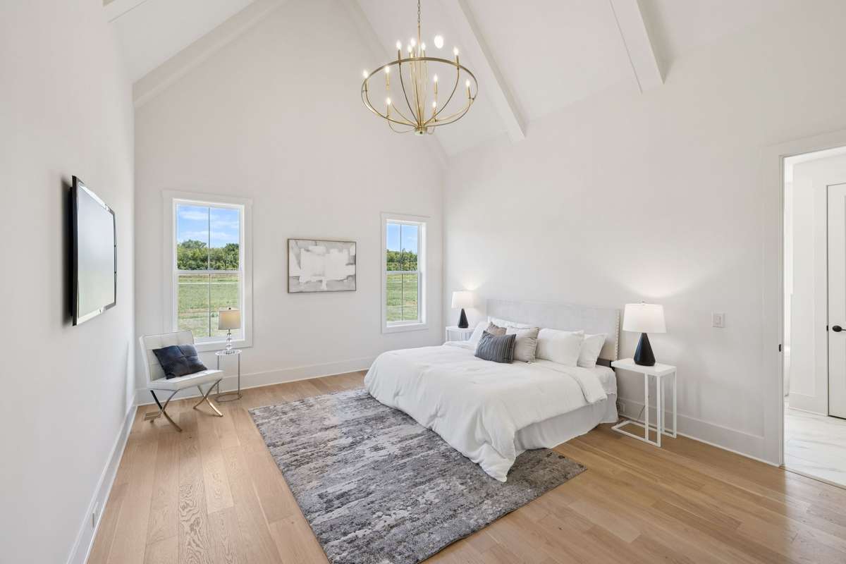 The Primary Suite Features A Vaulted Ceiling With Beams