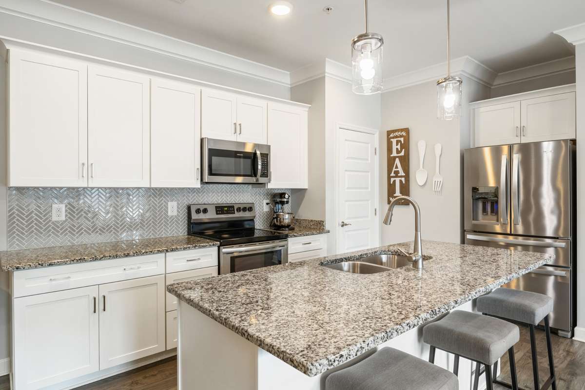 This stylish kitchen features lovely white cabinets, a gorgeous backsplash and granite countertop, upgraded crown moldings, pantry and stainless steel appliances lift this 1st floor condo to the next level. Refrigerator conveys.