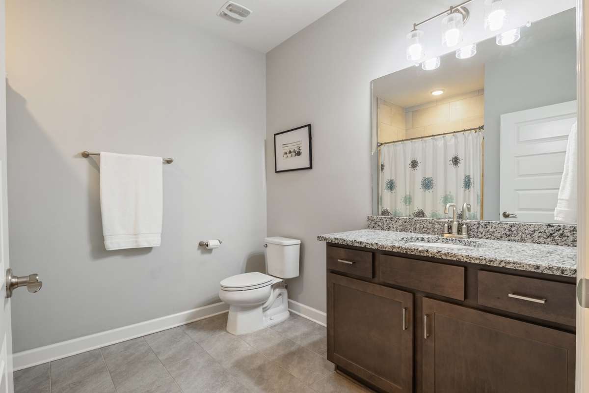 The oversized guest bath has a tub/shower combination with upgraded granite to match the kitchen and upgraded tile in the shower and on the floors.