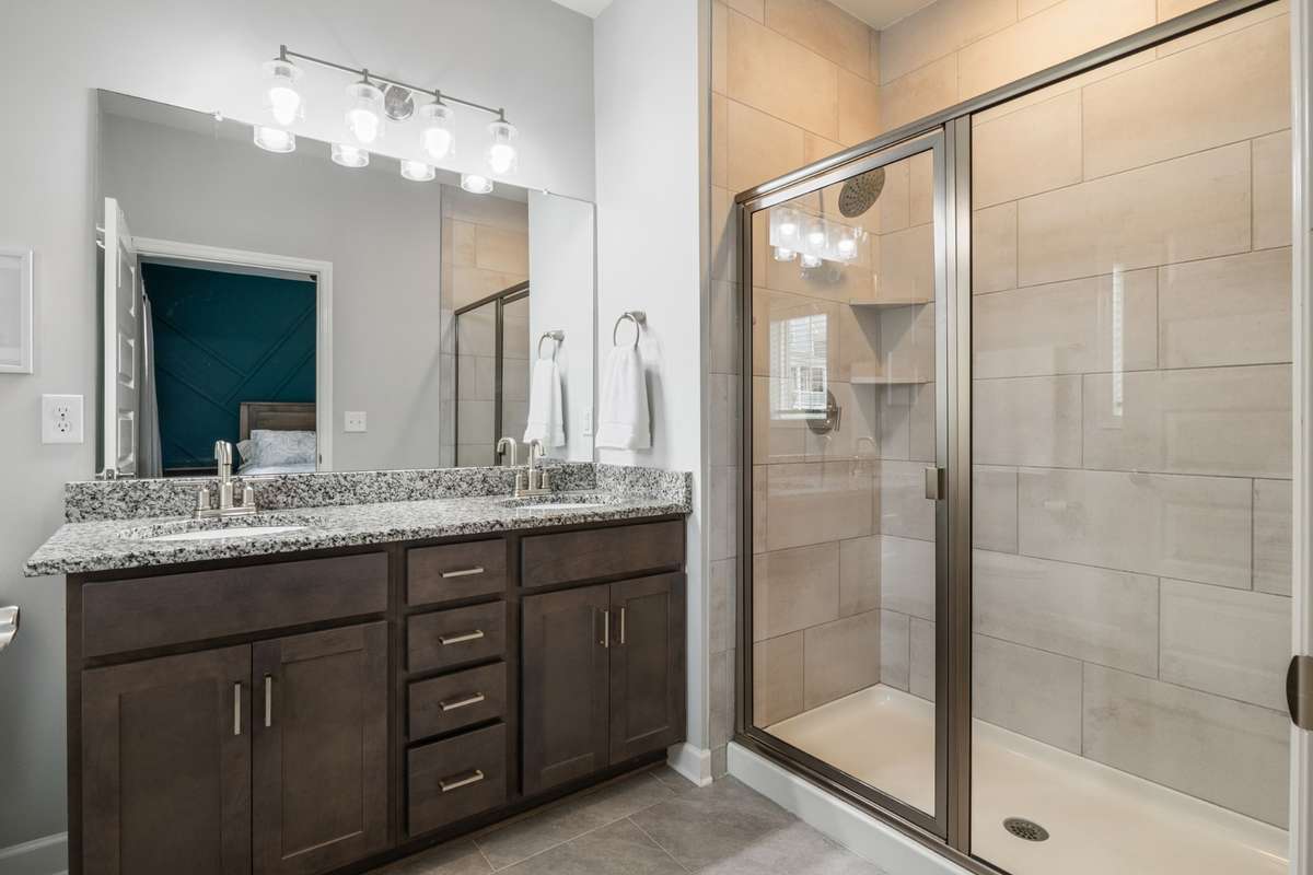 The owner's bath has an oversized shower with upgraded tile in the shower and on the floors and upgraded granite to match the kitchen. There is also a window for natural light.