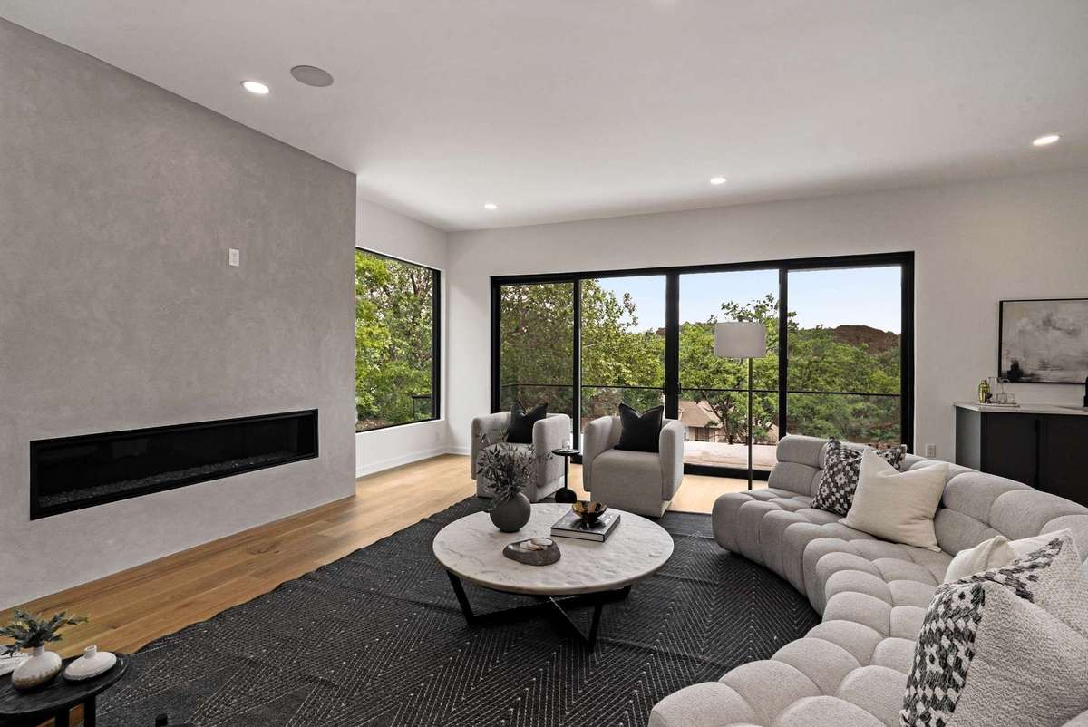 The living room features an incredible amount of space for entertaining. Stucco wrapped linear fireplace.