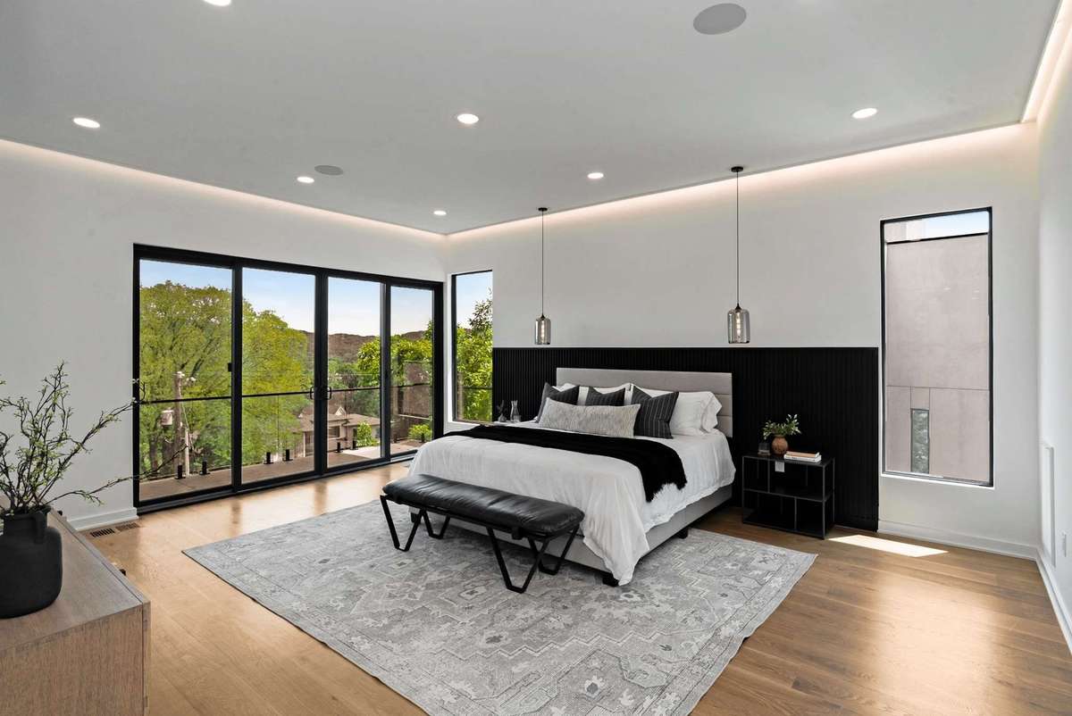 Upstairs to the primary suite with LED ceiling feature, headboard LED and balcony.