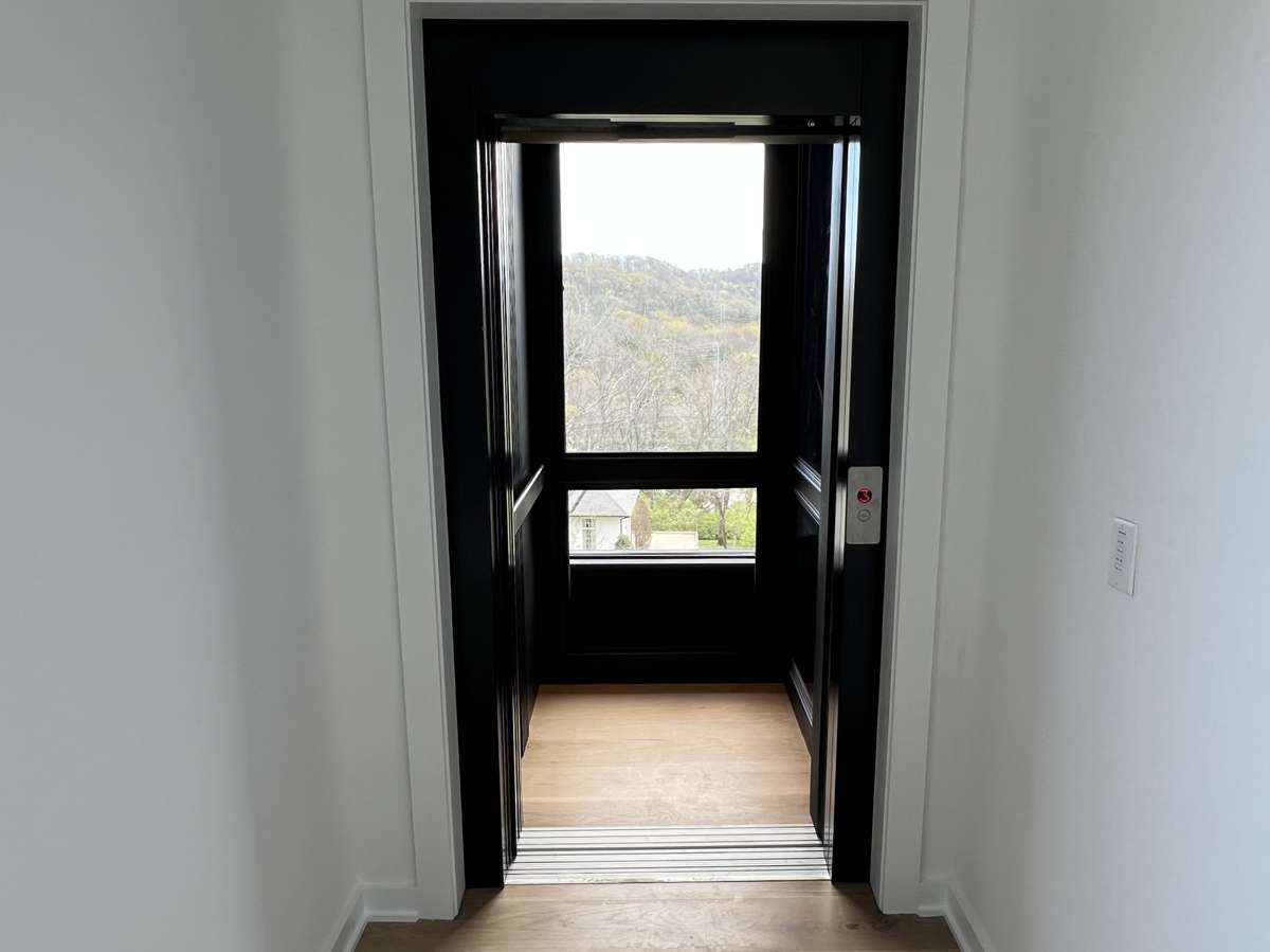 Motorized elevator doors and hillside view from inside the elevator