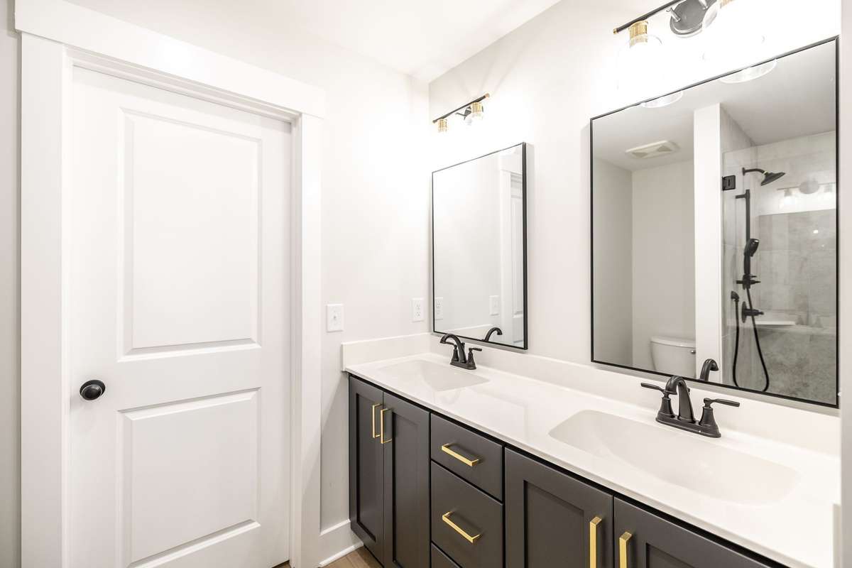 Primary bathroom has custom cabinetry with double vanity and designer finishes~