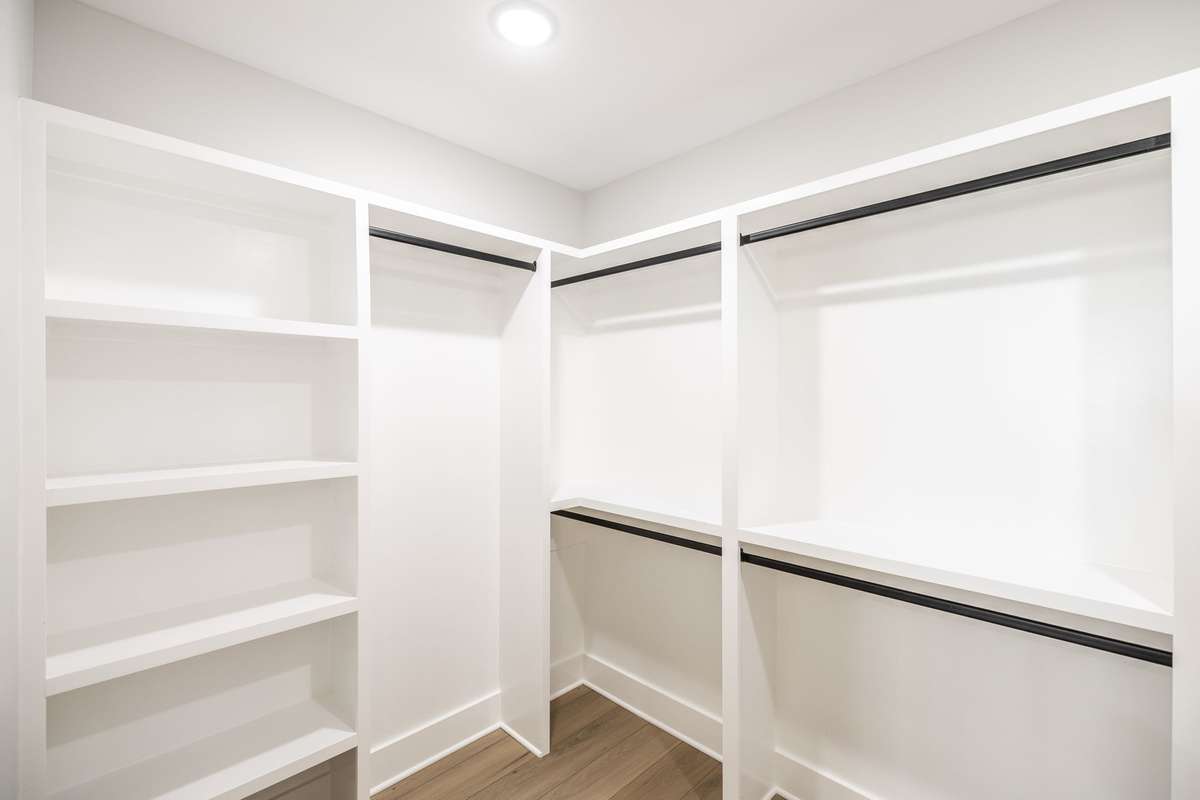 Primary closet is huge with custom wood shelving~