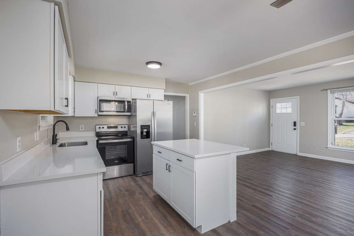 Now we head down the hallway next to the refrigerator. It's a typical Nashville ranch - the main hallway bath on the left, a secondary bedroom on the right, then further down we come to another secondary bedroom on the right and primary on the left