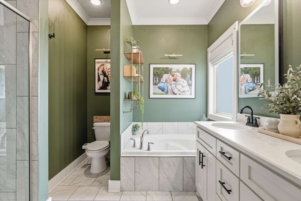 PRIMARY SUITE BATHROOM WITH DOUBLE SINKS AND A SEPARATE TUB AND TILE SHOWER