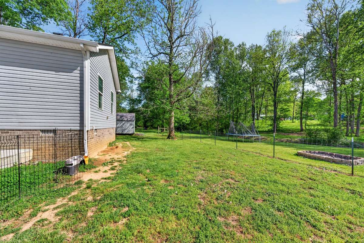 Backyard is partially fenced for a dog run area