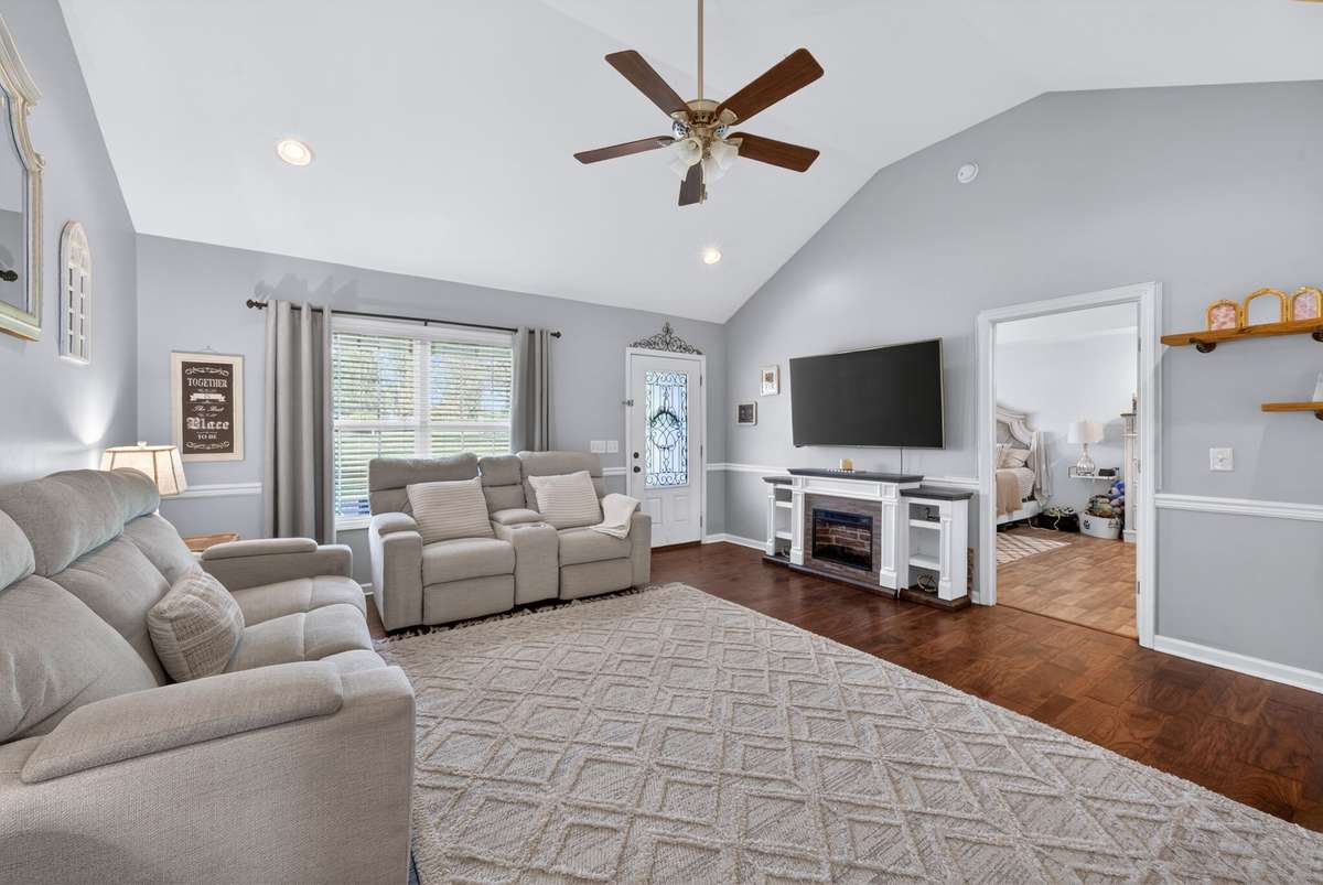 Spacious living room with soaring ceiling, chair railing and hardwood floors