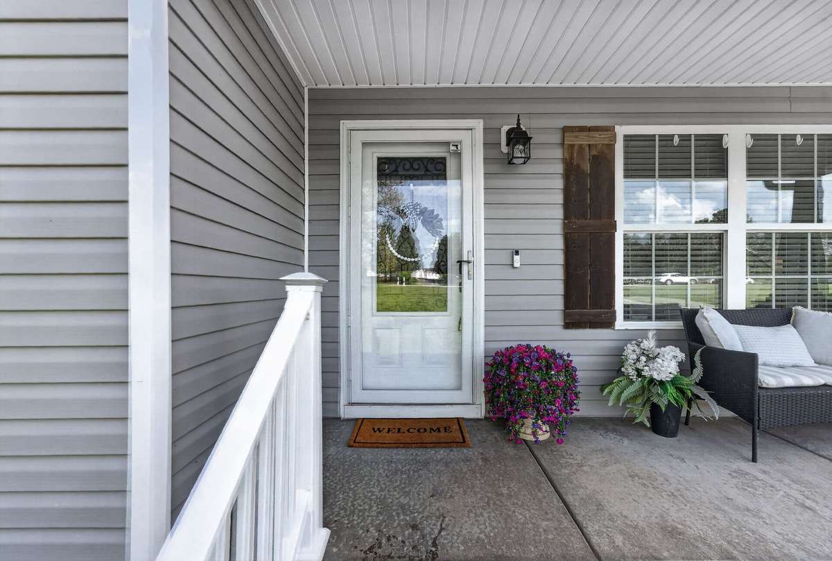 This home is beautifully constructed with grey siding,vinyl post, screen door, cedar shutters and a covered porch