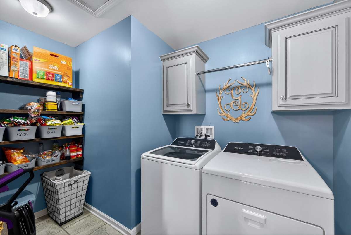 Spacious laundry room with cabinets and hanging area