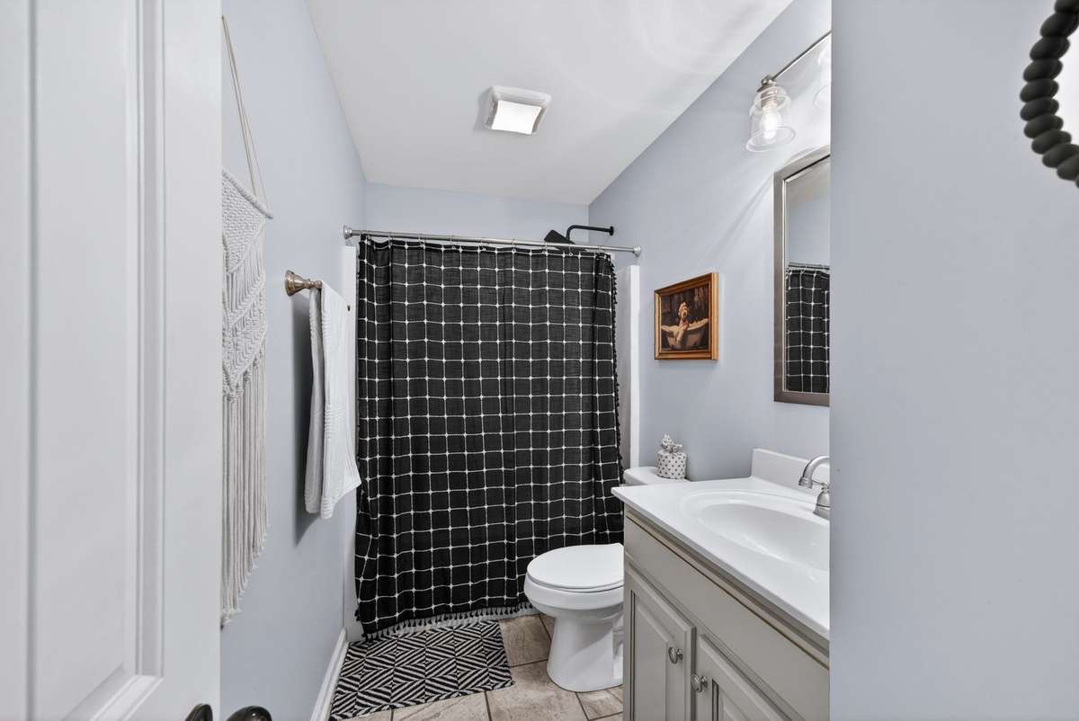 Hall bathroom with large vanity and tile floors