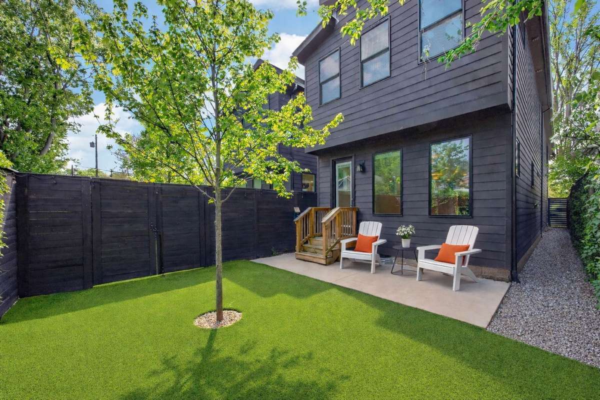 This charming back yard is as functional as it is inviting. The artificial turf is pet-friendly and maintenance-free, and the privacy fence adds a modern design element.