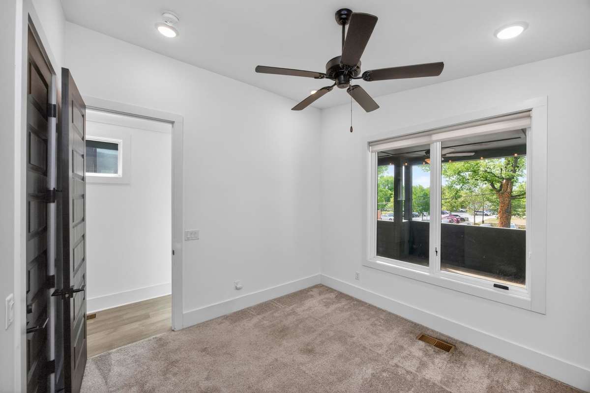 The third bedroom on the second level is located at the front of the house. Its windows look out onto the covered porch.