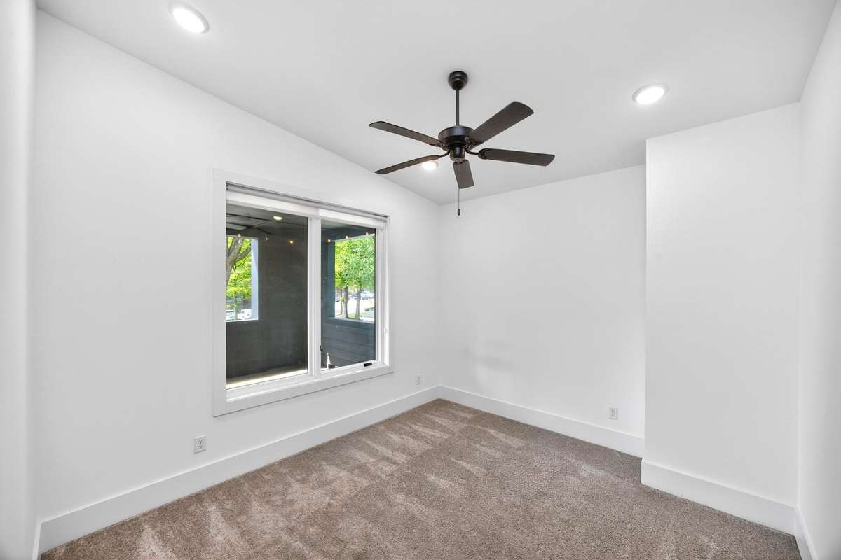 The third bedroom on the second level is located at the front of the house. Its windows look out onto the covered porch.