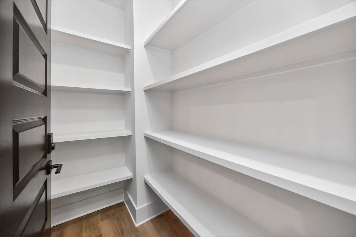 Large, walk-in pantry with plentiful built-in shelving.