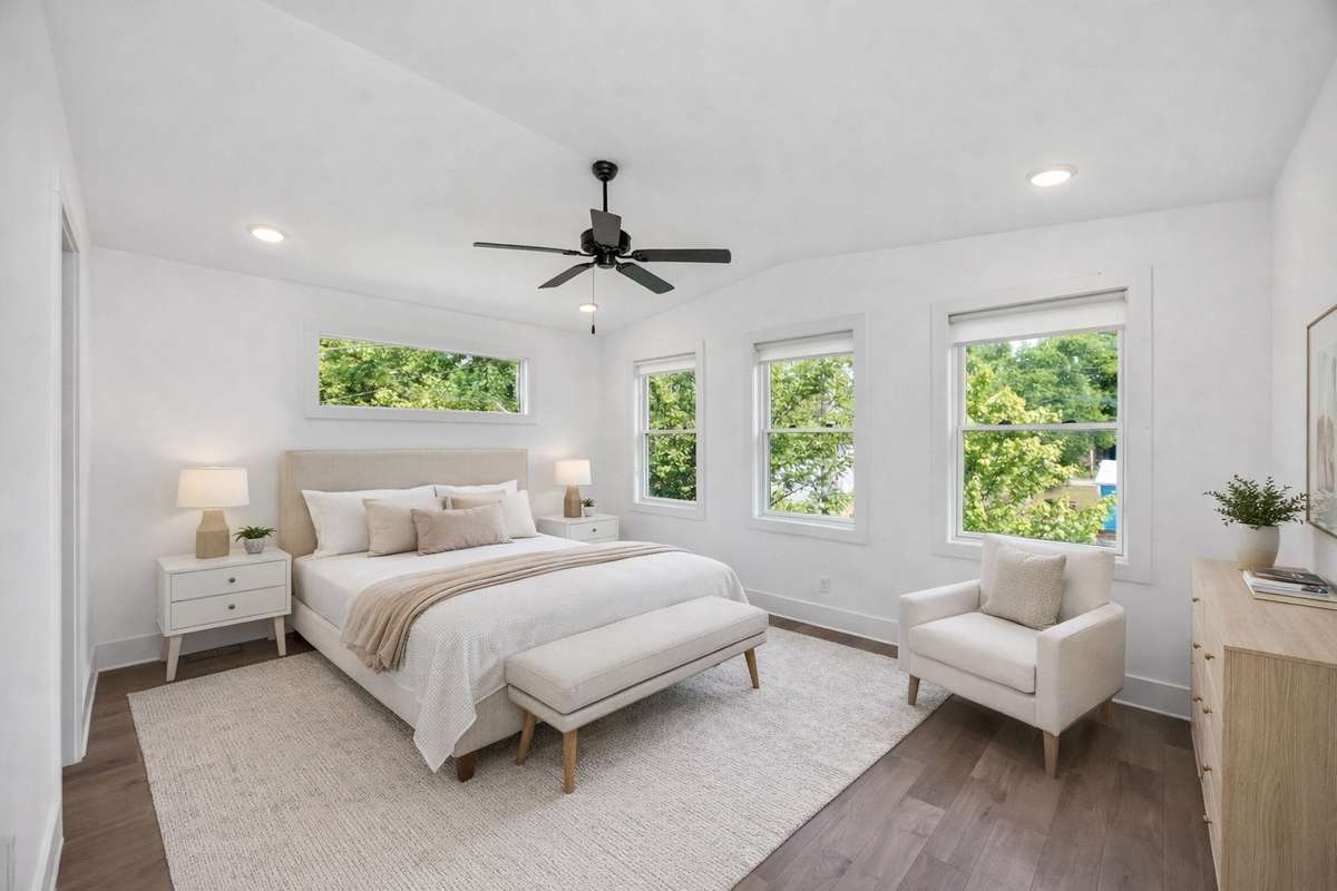 The primary bedroom is situated at the rear of the house, away from the other two bedrooms on the second level. With its vaulted ceiling and rich natural light, it feels like a serene retreat. Photo has been digitally staged.