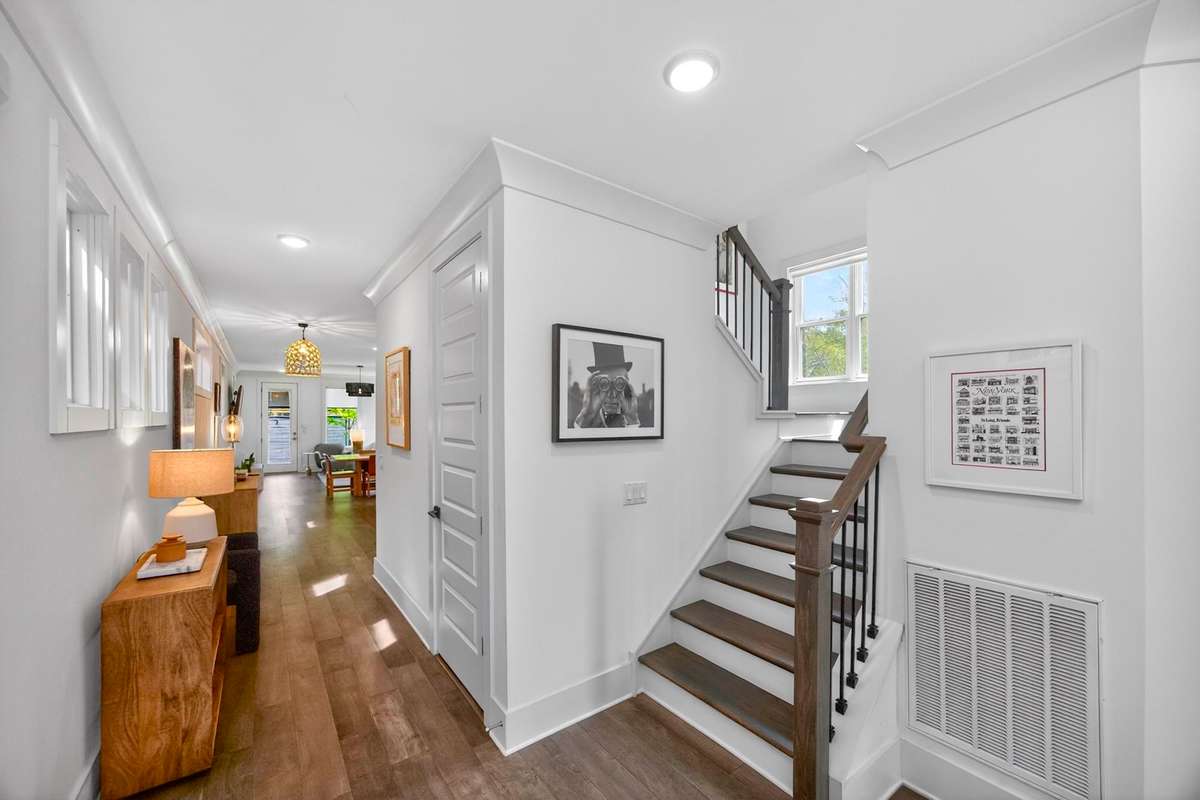 Graceful sightlines extend from the polished entry hall to the glass-panel door and windows at the rear of the house.