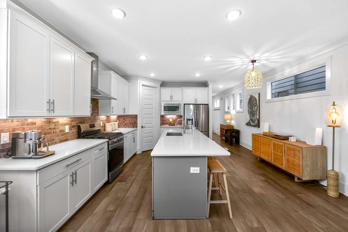 The kitchen lighting includes recessed task fixtures, warm under-cabinet lighting, and an extraordinary custom chandelier.
