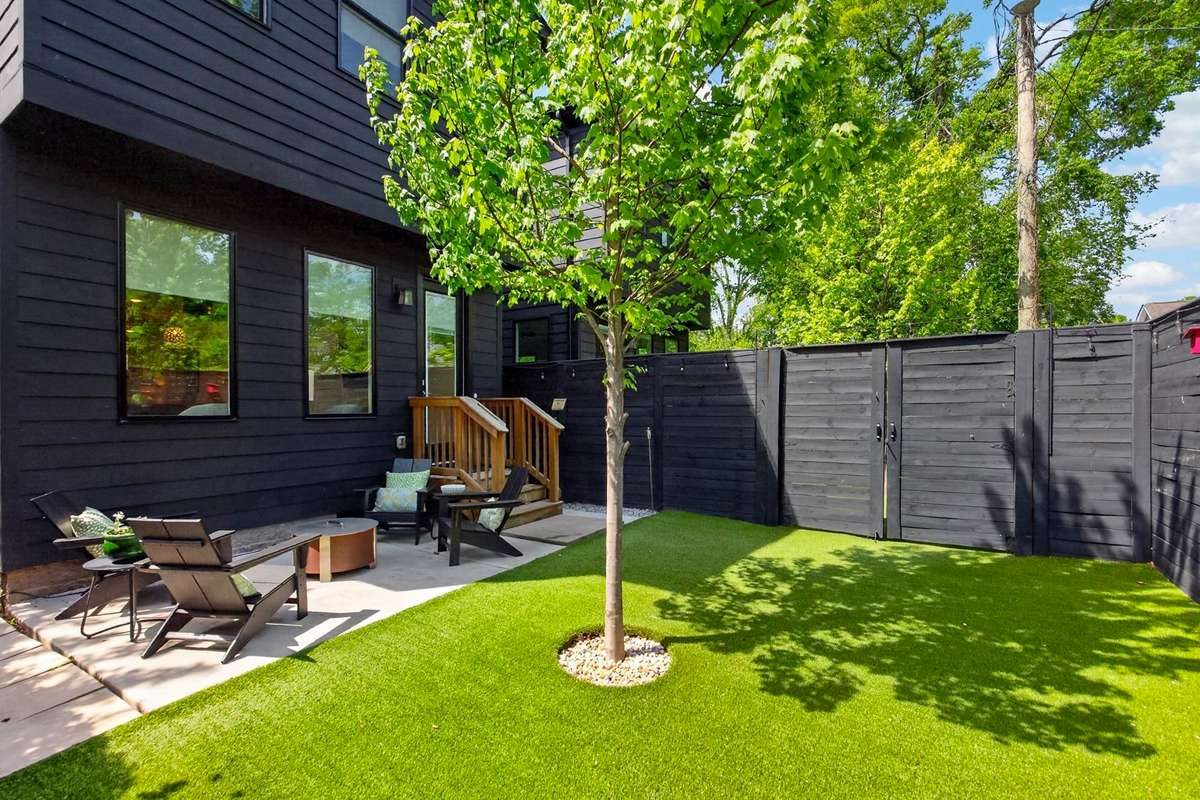 This charming back yard is as functional as it is inviting. The artificial turf is pet-friendly and maintenance-free, and the privacy fence adds a modern design element.