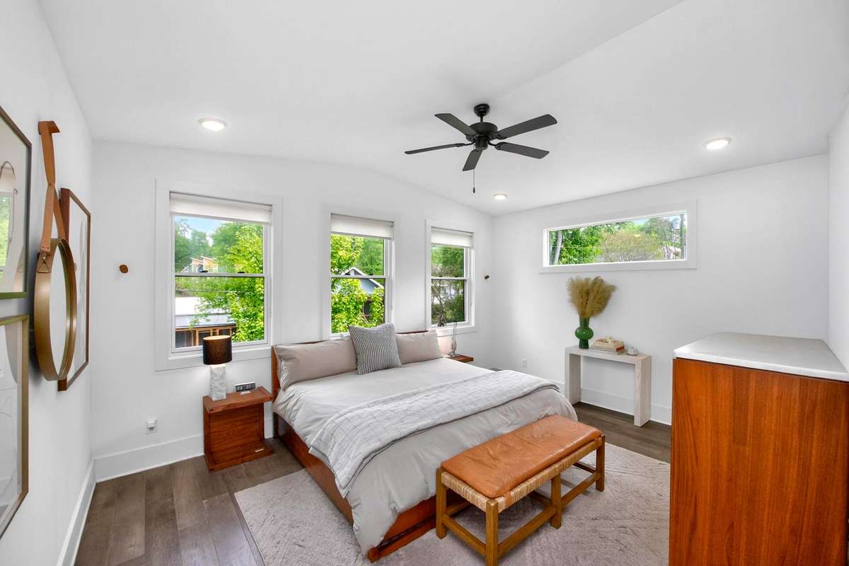 The primary bedroom is situated at the rear of the house, away from the other two bedrooms on the second level. With its vaulted ceiling and rich natural light, it feels like a serene retreat.