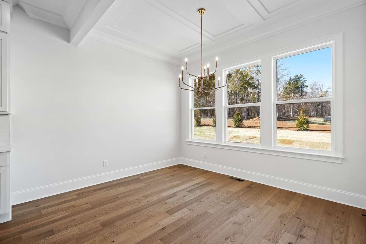 Enjoy starting your morning in this light filled Breakfast Nook. Notice the picture frame trimmed ceiling and brushed gold light fixture.
