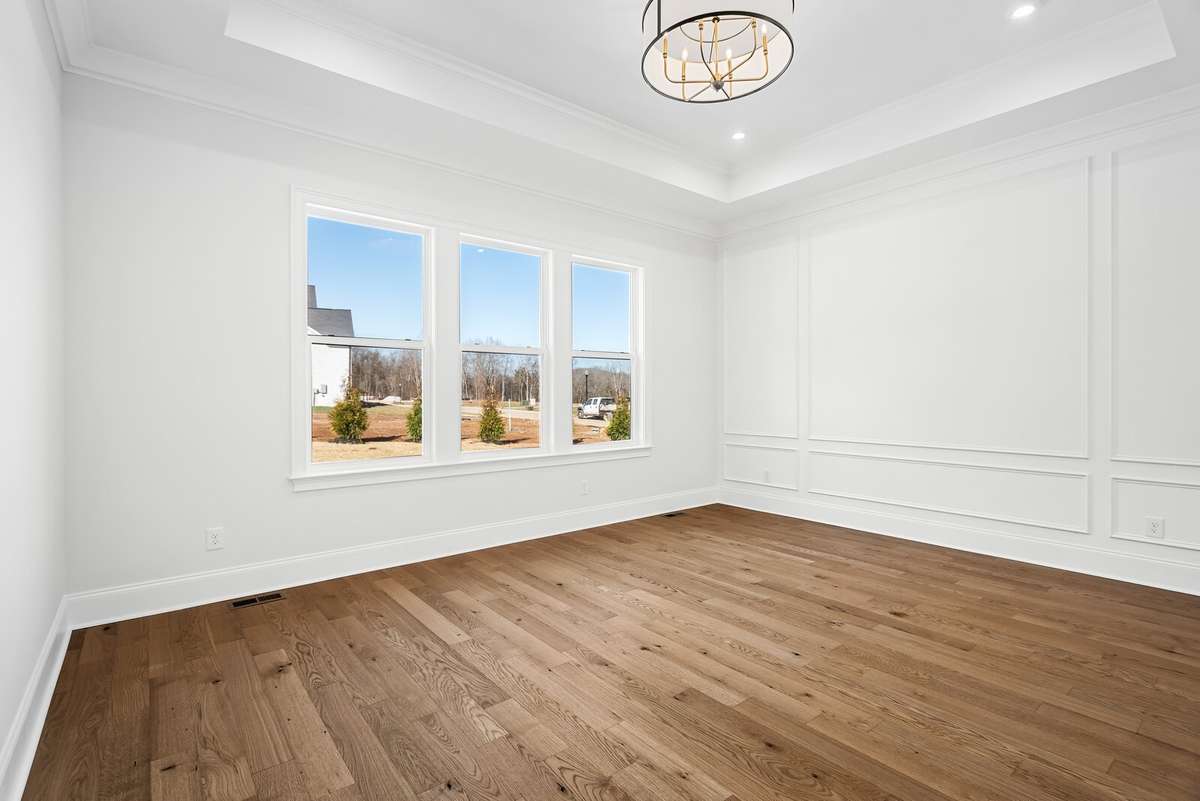 Main level Primary bedroom with large windows and beautiful picture frame wall trim.