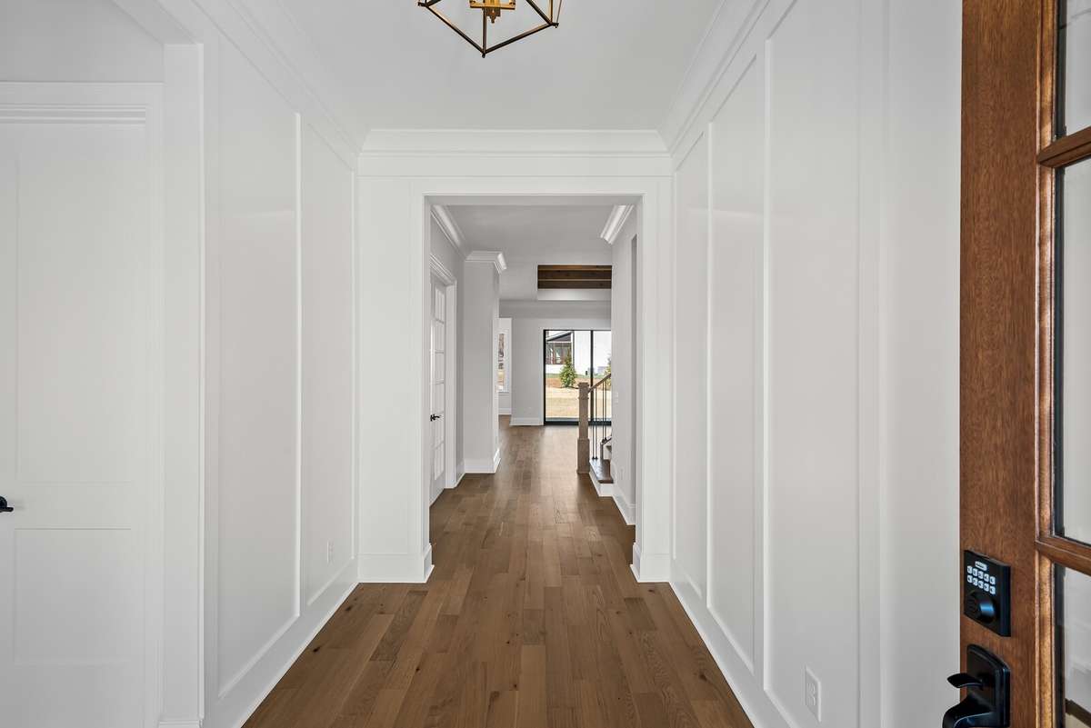 Trimmed walls welcome you into the home with beautiful light fixtures.