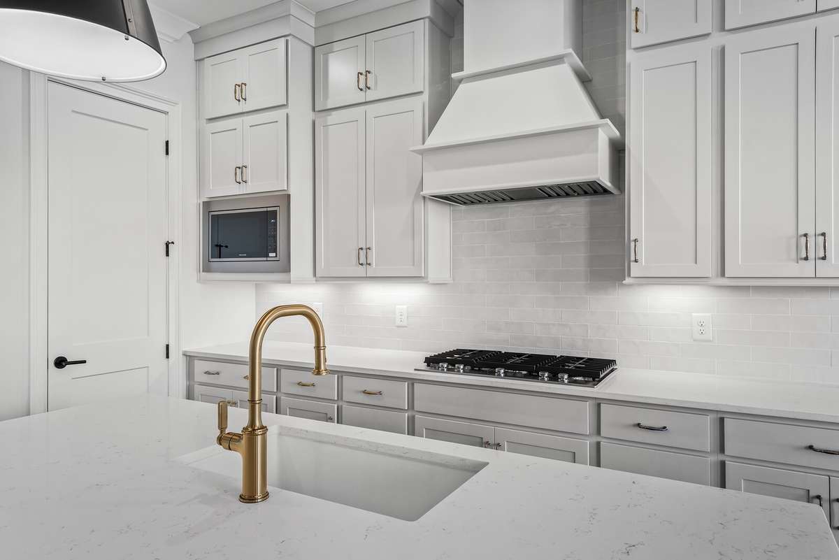 Granite composite sink with brushed gold plumbing fixtures.
