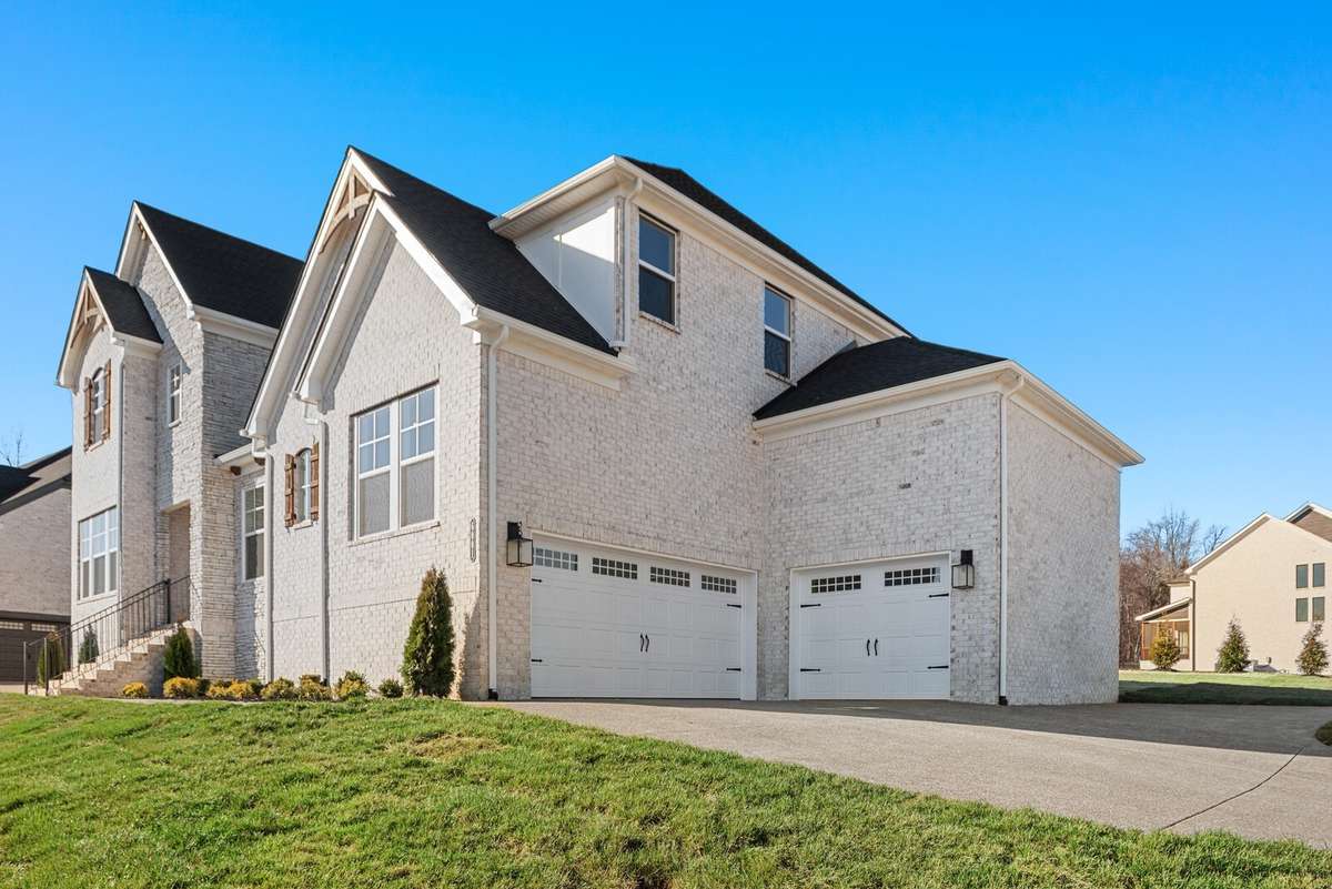 A two car side entry garage and one car carriage garage connect. Ample storage space within the garage and additional aggregate driveway has been added for parking space.