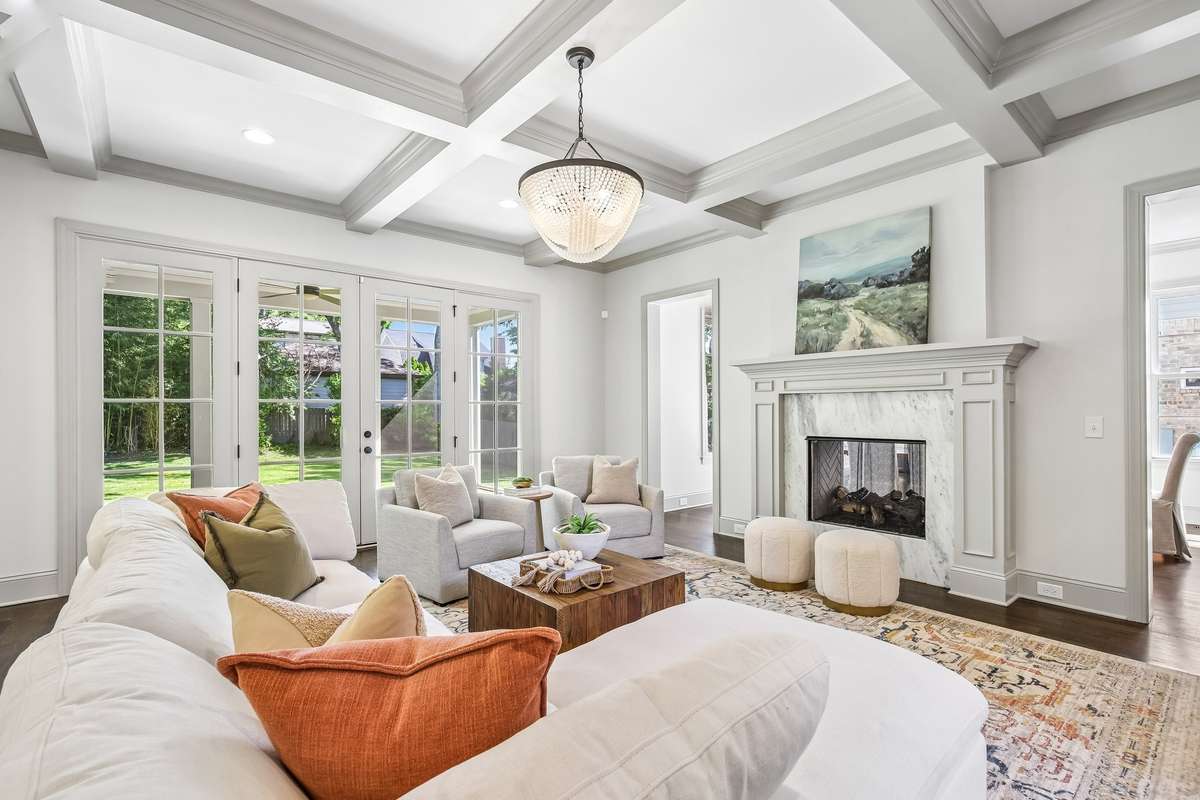 Bright living room with coffered ceilings, fireplace, and large windows