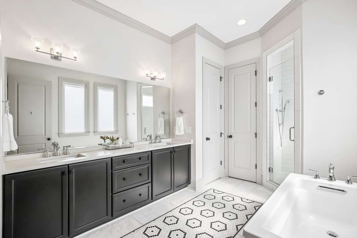 Primary bath with double vanity, soaking tub, and separate shower