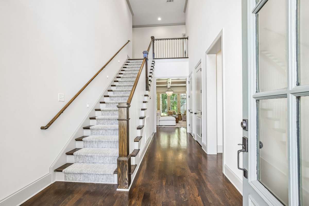Welcoming entry with staircase and hardwood floors.