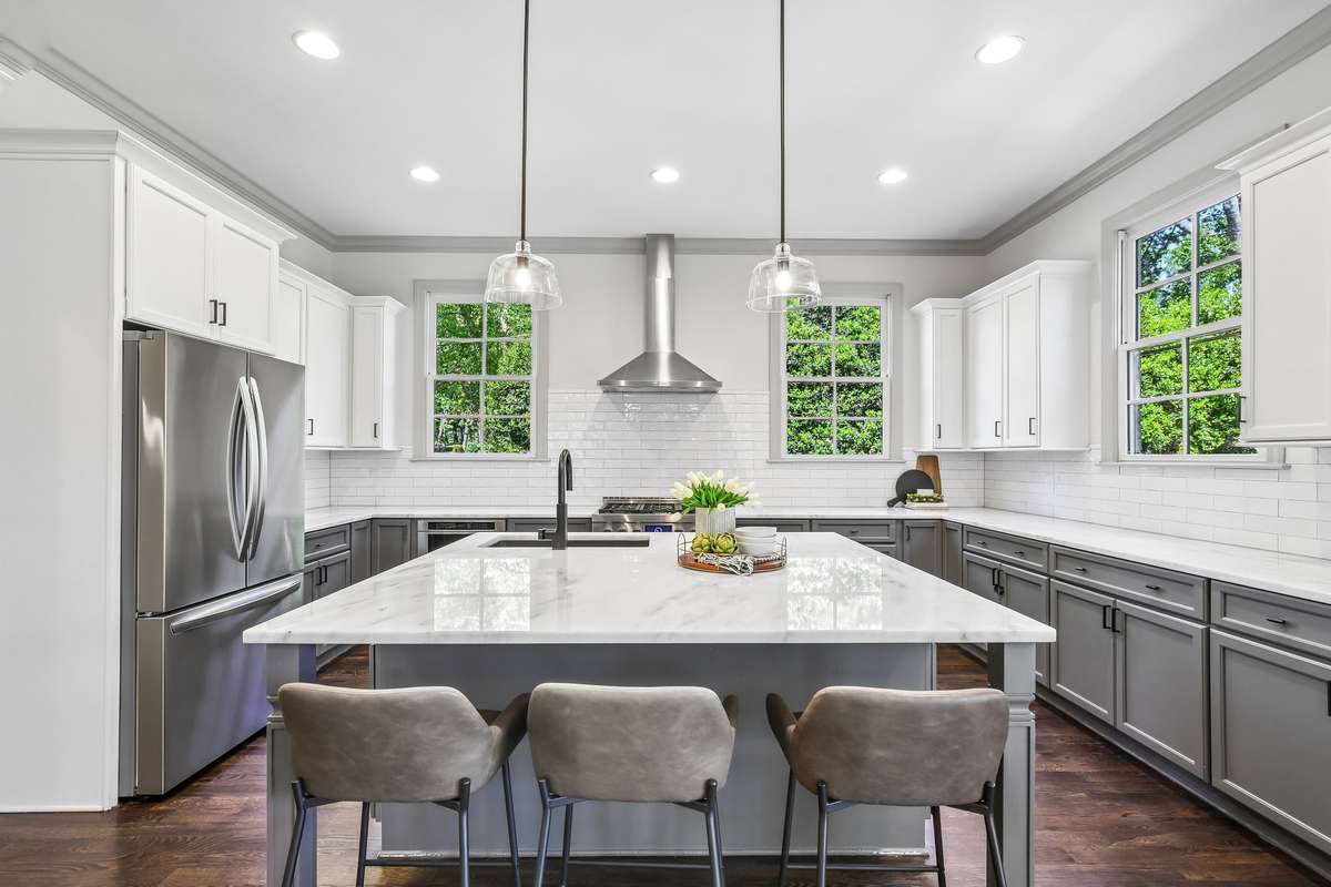 Spacious kitchen with oversized island, marble surfaces, and stainless appliances
